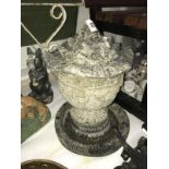 A concrete garden bird bath with urn and lid