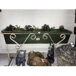 A plant trough on wrought iron stand