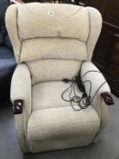 A cream fabric electric reclining armchair