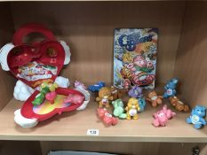 A collection of vintage plastic, care bears, and carry case.