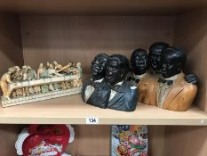 A pottery model of 3 black men in black jackets, and an Italian resin model of the last supper.