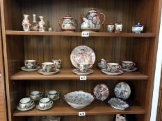 Three shelves of Chinese vases, cups and saucers, teapots etc.