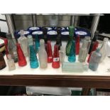 A quantity of coloured glass bottles & candlesticks