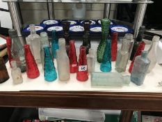 A quantity of coloured glass bottles & candlesticks