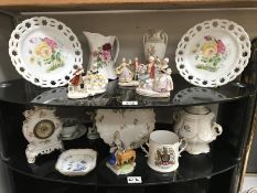 Two shelves of pottery and porcelain, including continental figures, ribbon plates etc.