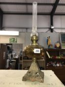 A Victorian oil lamp with amber glass font