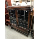 A 1930's oak display cabinet with leaded glass doors & drawer