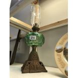 A Victorian oil lamp with green glass font