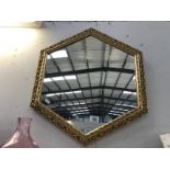 An ornate hexagonal, framed mirror.