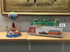 Two tinplate, clockwork toys, a rocket-ship carousel and a car race track.