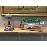 Two tinplate, clockwork toys, a rocket-ship carousel and a car race track.