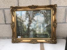 A gilt framed print of a church.