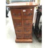 A dark stained hard wood chest of 8 drawers