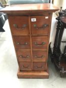 A dark stained hard wood chest of 8 drawers