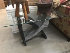 A glass topped table with sculptured base