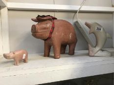 A carved stone dolphin group and pig and a large terracotta pig