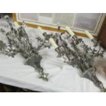 An unusual pair of silver coloured 3 branch wall lights decorated with ceramic flowers.