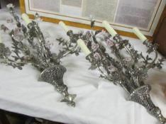 An unusual pair of silver coloured 3 branch wall lights decorated with ceramic flowers.