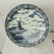 A Delft blue and white charger depicting a windmill.