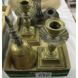 A pair of brass candlesticks, a brass bell, a double chamber stick and a miniature flat iron.
