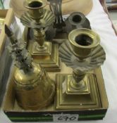 A pair of brass candlesticks, a brass bell, a double chamber stick and a miniature flat iron.