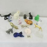 15 small cat figures and a metal figure of a dog.
