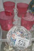 4 cranberry glass beakers and a glass paperweight.