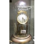 An anniversary clock under glass dome, in good working order.