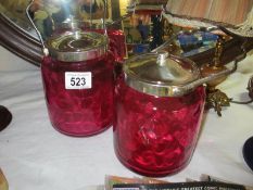Two cranberry glass biscuit barrels with silverplate lids with handles
