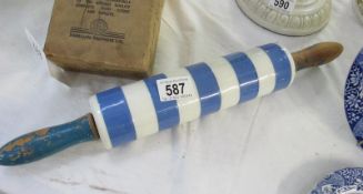 A vintage china blue and white hooped rolling pin with wooden handles
