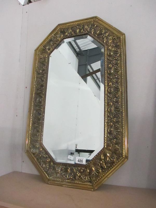 An elongated hexagonal ornate gilt framed mirror