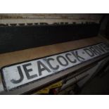 A pressed aluminium 'Peacock Drive' street sign.
