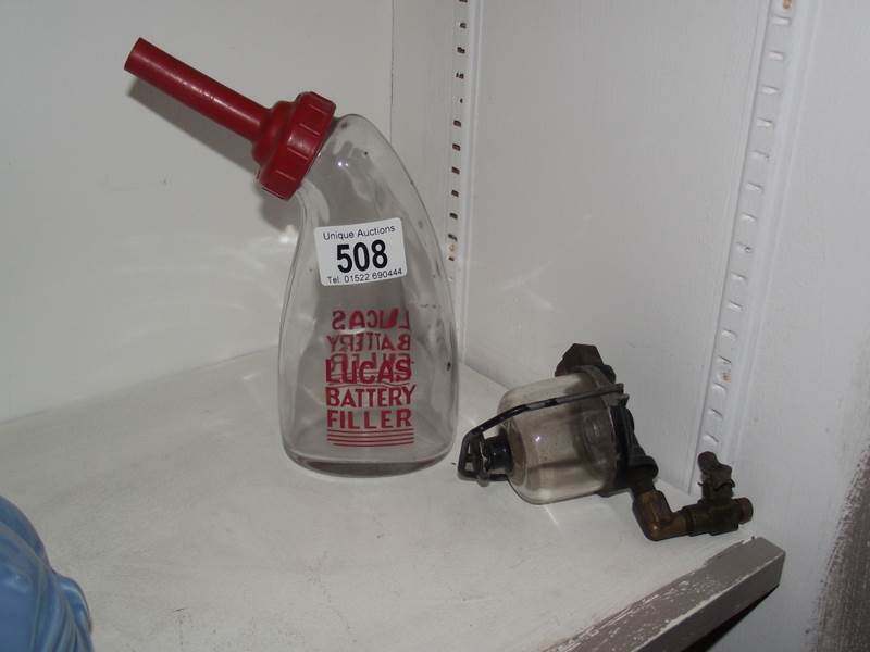A glass Lucas battery filler bottle and a pre war brass fuel filter housing.