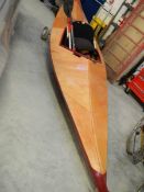 A fibreglass reinforced plywood leisure canoe with paddles.