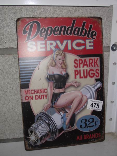 A retro metal spark plug advertising sign.