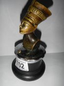 A bronze car mascot being a bust of Nefertiti.