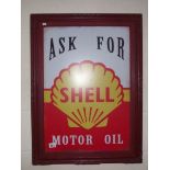 A retro 'Ask for Shell Motor Oil' sign in an old frame.
