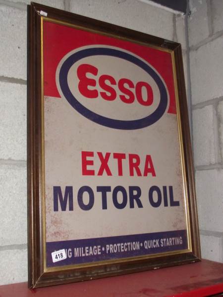 A retro Esso Extra Motor Oil metal sign in an old wooden frame.