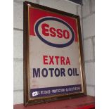 A retro Esso Extra Motor Oil metal sign in an old wooden frame.