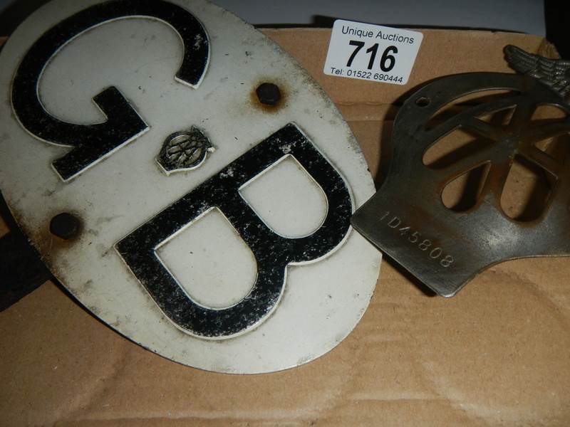 An AA car badge and a GB plaque.