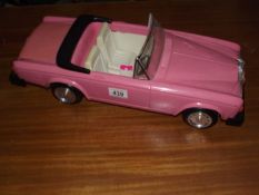 A large plastic model of a Rolls Royce convertible.