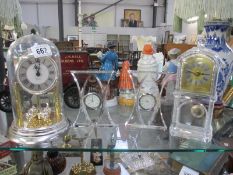 3 glass clocks and a clock under dome