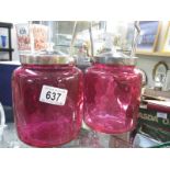 Two cranberry biscuit barrels with metal lids and handles