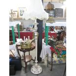 A white and gold painted wooden standard lamp with shade