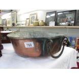 A large copper bowl with handle