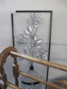 A metal picture of a flower in vase