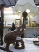 A lamp with wooden elephant as base