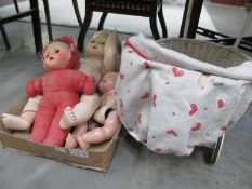 Three vintage dolls and a child's pram