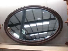 A wooden framed oval mirror