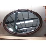 A wooden framed oval mirror